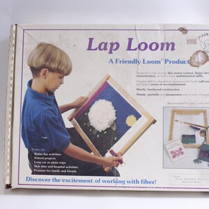 May include: A wooden lap loom with a child using it to weave a colorful tapestry. The box features the text "Lap Loom" and "A Friendly Loom Product".