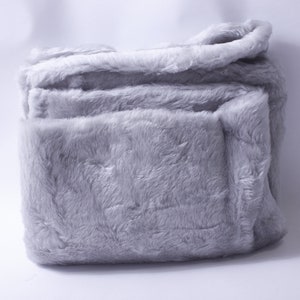 May include: A soft, gray plush blanket folded neatly. The blanket is made of a fuzzy, faux fur material.