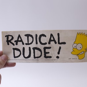 May include: A yellow and white sticker with the text "RADICAL DUDE!" in black lettering. A cartoon image of Bart Simpson is on the right side of the sticker.