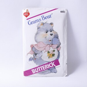 May include: A vintage sewing pattern featuring Grams Bear from the Care Bears. The pattern is from Butterick and has the number 6933 printed on it.