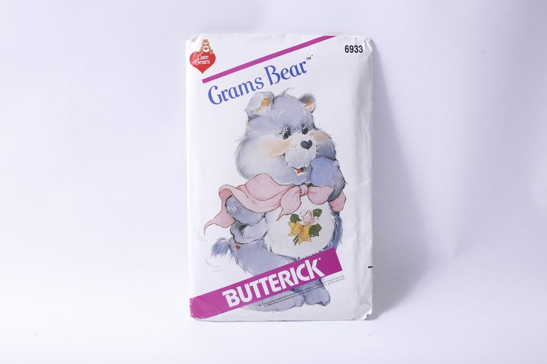 May include: A vintage sewing pattern featuring Grams Bear from the Care Bears. The pattern is from Butterick and has the number 6933 printed on it.