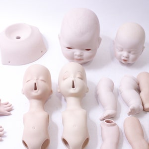 May include: A set of porcelain doll parts, including heads, torsos, arms, and legs. The parts are unpainted and ready to be customized.