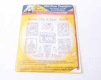 May include: A yellow and red pamphlet with the title "Some Like it Hot!" and the number "4004". The pamphlet is for hot iron transfers and features six different designs, including a chilli pepper, a bottle of vinegar, and a fiesta sign. The pamphlet is printed in English, French, and Spanish.