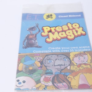 May include: A vintage E.T. Closet Hideout Presto Magix sticker book. The cover features a cartoon image of E.T. with the text "Create your own scene. Complete with over 25 transfers."