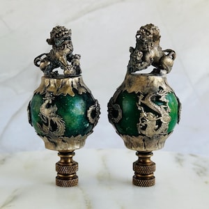 May include: Two green and silver finials with dragon and phoenix designs. The finials are topped with silver lion figurines.