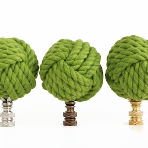 May include: Three green rope finials with different colored metal bases. The finials are made of thick, twisted rope and are in the shape of a knot.