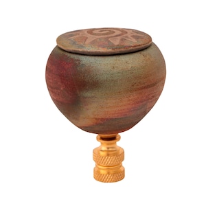 Peut inclure: Un fleuron de lampe en céramique avec une base ronde de couleur verte, rouge et marron et un couvercle avec un motif de soleil. Le fleuron a une base en métal doré.