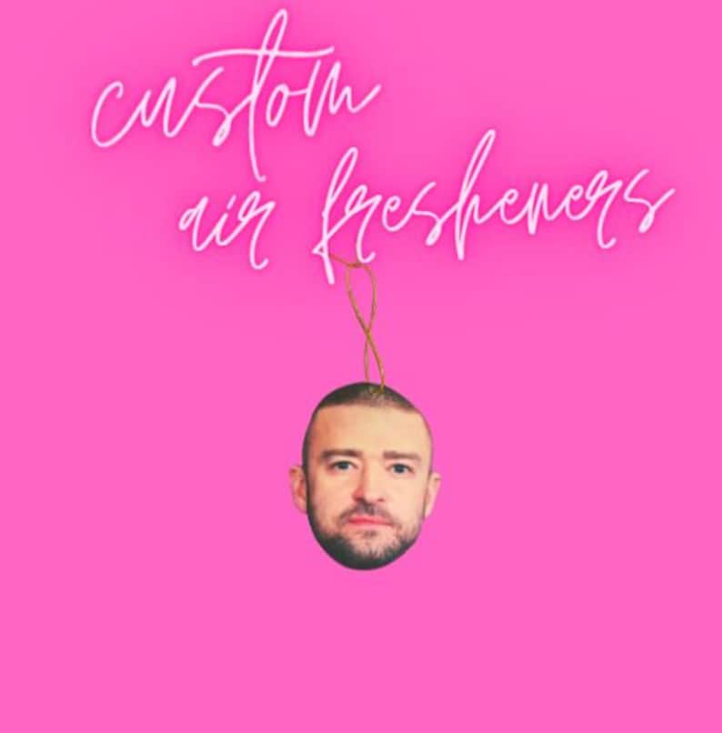 Peut inclure: Un d&eacute;sodorisant personnalis&eacute; avec le visage d'une c&eacute;l&eacute;brit&eacute;, suspendu par une ficelle dor&eacute;e, sur un fond rose vif. Le texte blanc en cursive au-dessus indique "custom air fresheners".