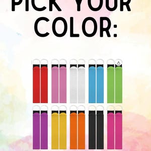 May include: A collection of long, rectangular fabric wristlet straps with silver-toned metal rings at the top, arranged in two rows. The straps are available in red, pink, white, blue, green, purple, yellow, orange, black, and magenta. Text reads: PICK YOUR COLOR: