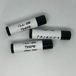 May include: Three black lip balm tubes with white labels. The labels have the text "I'll be there" and "For you" on two of the tubes. The third tube has the text "F.R.I.E.N.D.S" on the label.