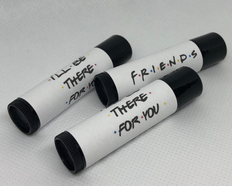 May include: Three black lip balm tubes with white labels. The labels have the text "I'll Be There For You", "There For You", and "Friends" with colorful dots.