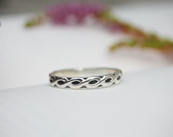 May include: A silver ring with a braided design. The ring is simple and elegant.