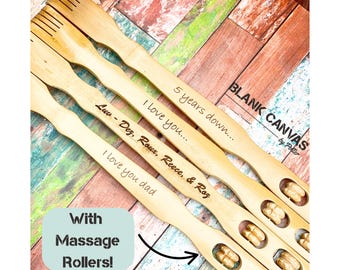 May include: Four wooden back scratchers with engraved text: "I love you dad", "Luv - Dez, Roux, Reece, & Roz", "I love you...", and "5 years down...". Each scratcher has massage rollers and a comb-like end. The text "With Massage Rollers!" is also visible.