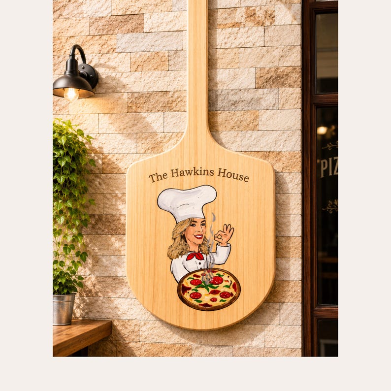 May include: A wooden pizza peel sign featuring the text The Hawkins House, an illustration of a chef in a white hat and uniform making a hand gesture, and a pepperoni pizza graphic. The sign has a light wood grain finish and a long handle.