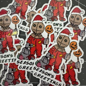May include: A collection of stickers featuring a cartoon character dressed in a red jumpsuit and a Santa hat, holding a candy cane with a pumpkin on top. The stickers have different text, including "Season's Greetings" and "Season's Son's Greetings".