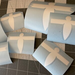May include: Multiple sheets of blue vinyl with white stick-on decals of a stylized human figure with outstretched arms.