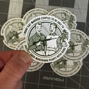 May include: A collection of circular stickers featuring a vintage-style illustration of two men, one holding a gun and the other a marijuana plant. The text on the sticker reads, "I WANT GAY MARRIED COUPLES TO BE ABLE TO PROTECT THEIR MARIJUANA PLANTS WITH GUNS."