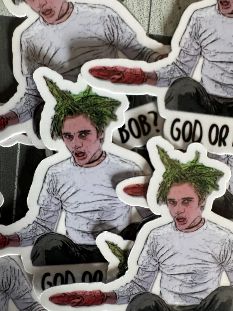May include: A set of stickers featuring a character with green hair and a white shirt. The stickers have the text "BOB? GOD OR" and "GOD OR" on them.