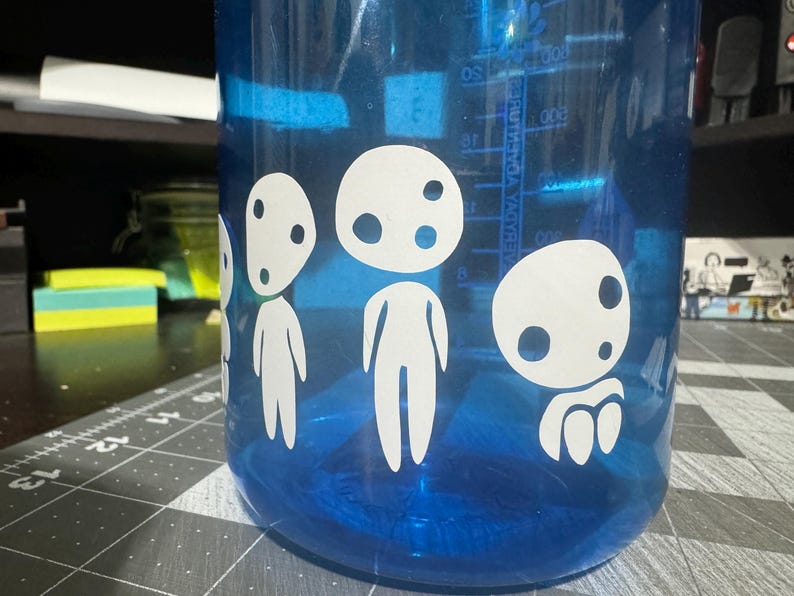 May include: A blue water bottle with white vinyl stickers of four characters from the animated film "My Neighbor Totoro".
