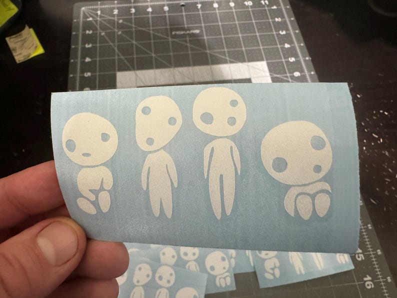 White inyl decal featuring four Kodama forest spirits from Princess Mononoke, Studio Ghibli anime design. Durable waterproof vinyl for cars, laptops, or gifts.