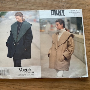 Pode incluir: Um padrão de costura vintage da Vogue Patterns com um design DKNY. O padrão mostra um casaco com uma gola grande em duas variações de cores: verde escuro e bege. O padrão está rotulado como "American Designer".