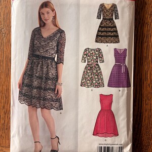 May include: New Look sewing pattern 6370 for a dress with a V-neckline, three-quarter sleeves, and a belted waist. The envelope displays four variations, including lace, floral, and solid fabric options in sizes U.S. 8-18 and Euro 34-44.