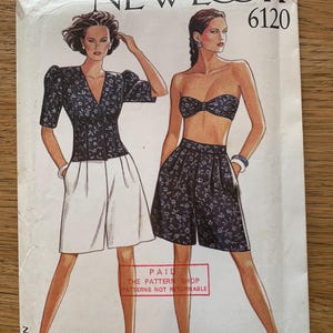 May include: A New Look 6120 sewing pattern envelope featuring illustrations of two outfits. One shows a dark floral print top with puff sleeves and white shorts. The other shows a dark floral print bandeau top and matching shorts. Text includes PAID THE PATTERN SHOP PATTERNS NOT RETURNABLE.