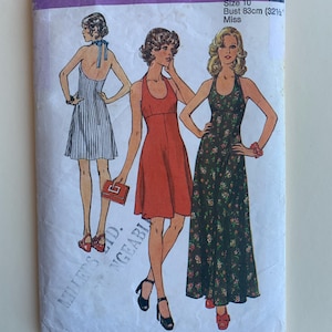 Puede incluir: Patrón de costura Simplicity número 5916 para un vestido. El patrón incluye tres estilos diferentes: un vestido a rayas con escote halter, un vestido rojo con escote halter y un vestido de estampado floral con escote halter. El patrón es para la talla 10, pecho 83 cm (32 1/2 pulgadas).