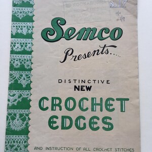 Puede incluir: Un folleto de instrucciones vintage titulado Semco Presents Distinctive New Crochet Edges and Instruction of All Crochet Stitches. La portada presenta un borde vertical verde con patrones de ganchillo blancos y texto verde sobre un fondo beige.