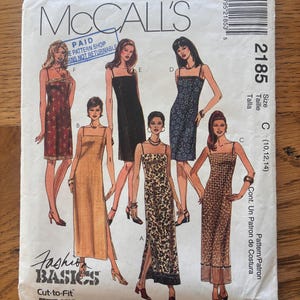 May include: A McCall's 2185 sewing pattern envelope for dresses in sizes 10, 12, and 14. The white paper envelope features illustrations of six different dress styles with varying lengths, patterns, and solid colors, along with a barcode and text.