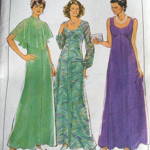 May include: A sewing pattern featuring three different dress designs. The dresses are a green dress with a cape, a green dress with a floral pattern, and a purple dress with a striped pattern. The pattern is for size 14, bust 92 cm.