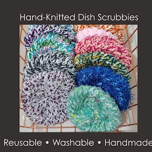 May include: A collection of hand-knitted dish scrubbies in a copper wire basket. The scrubbies are round and come in various colors, including purple, green, blue, pink, and white. The text "Hand-Knitted Dish Scrubbies" is at the top of the image, and "Reusable • Washable • Handmade" is at the bottom.