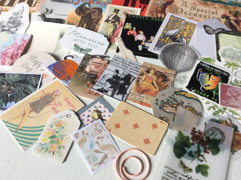 May include: A collection of vintage ephemera, including postcards, tags, and illustrations. The assortment features images of butterflies, birds, and botanical elements, along with text that reads "Memories with you", "Happy Day", and "Simple to mail". A decorative paper clip is also included.