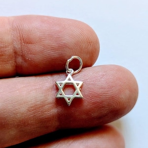 May include: A silver charm in the shape of a Star of David.