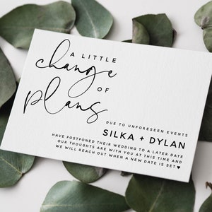 Peut inclure: Une carte blanche avec du texte noir annon&ccedil;ant un changement de plans pour un mariage en raison d'&eacute;v&eacute;nements impr&eacute;vus. La carte indique "A Little Change of Plans" et "Silka + Dylan".