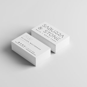 May include: A stack of white business cards with the text "Saburra & Stone Bath & Body Care" on the top card and "Alison Westbrook Founder & CEO" on the bottom card.