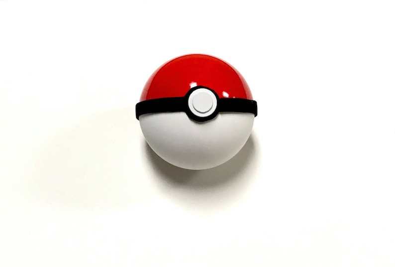May include: A red and white Poke Ball with a black band around the middle. The Poke Ball has a white button in the center.