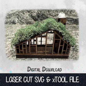 May include: A laser cut wooden model of a house with a moss covered roof. The model is designed for use with a laser cutter and includes a digital download of the SVG and xTool files.