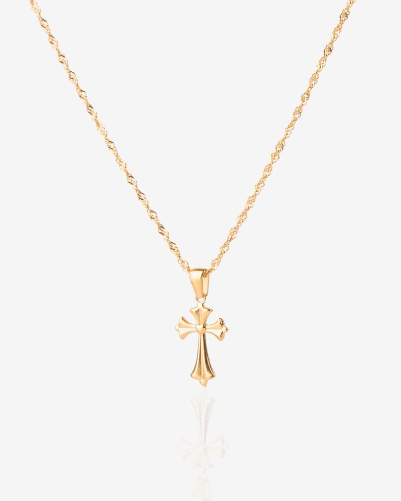 May include: A gold chain necklace with a small, ornate gold cross pendant.