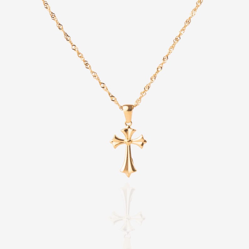 May include: A gold chain necklace with a small, ornate gold cross pendant.