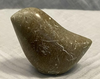 May include: A small, smooth, stone bird sculpture in shades of brown and gray. The bird has a rounded body and a pointed beak, with white veining throughout the stone. The sculpture is a decorative item.