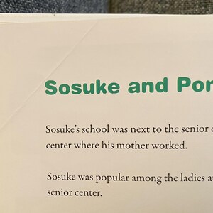 May include: A page from a book with the title "Sosuke and Ponyo" in green text. The text below describes Sosuke's school and his popularity at the senior center. The page has a cream-colored background.