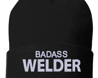 May include: Black knit beanie with white embroidered text that reads "BADASS WELDER".