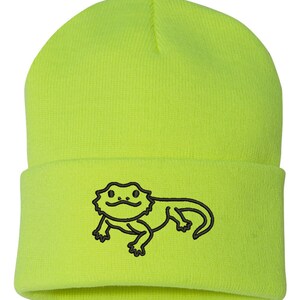 May include: A bright yellow beanie with a black embroidered bearded dragon design.