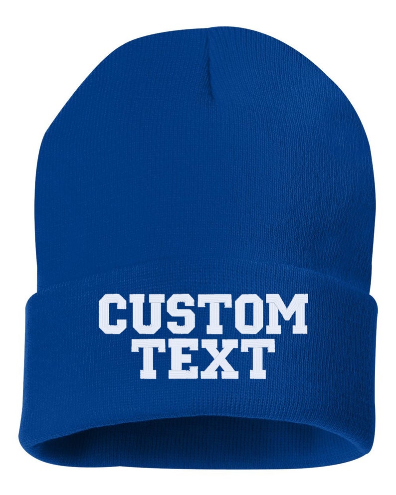 May include: A royal blue beanie with white text that reads "CUSTOM TEXT".