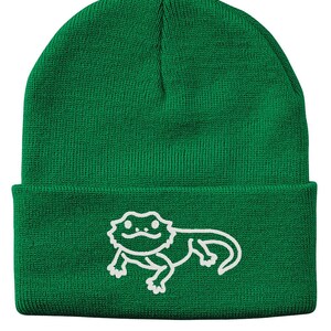 May include: Green knitted beanie with a white outline of a bearded dragon on the front.