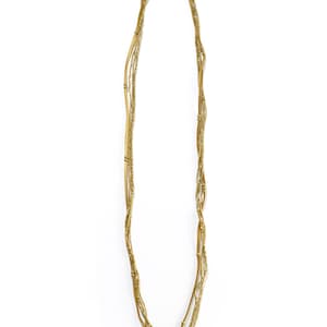 Puede incluir: Un collar de m&uacute;ltiples hilos con peque&ntilde;as cuentas doradas y detalles de cuero.