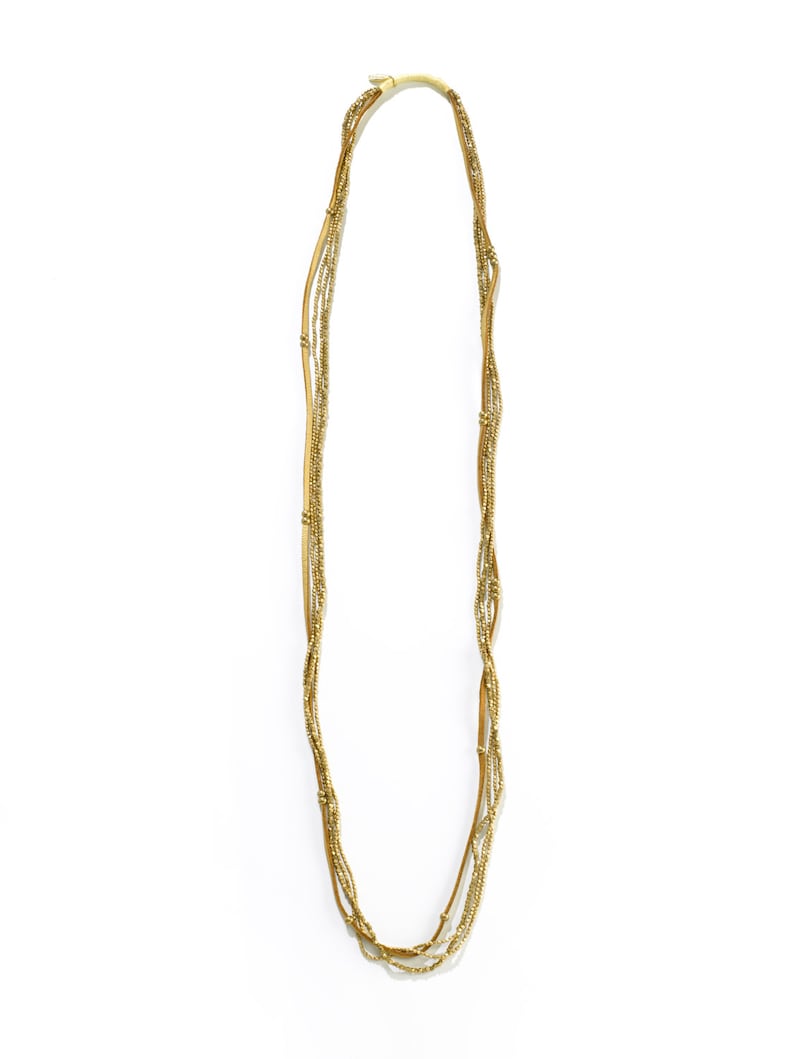 Puede incluir: Un collar de m&uacute;ltiples hilos con peque&ntilde;as cuentas doradas y detalles de cuero.
