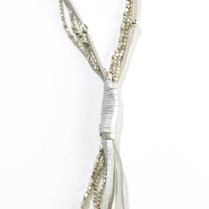 May include: A silver multi-strand necklace with a leather cord and small beads.