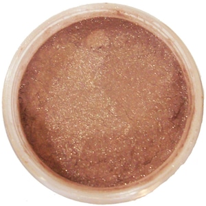 Può includere: Un contenitore pieno di polvere scintillante color bronzo. La polvere ha una consistenza glitterata e sembra essere un prodotto cosmetico, forse ombretto o illuminante. Il contenitore è rotondo con un corpo in plastica trasparente.